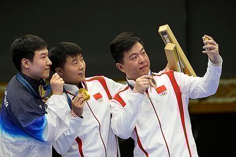 Men's 25m rapid fire pistol: Bronze medalist China's Wang Xinjie, right, take a selfie with gold medalist and fellow countryman Li Yuehong, center, and silver medalist South Korea's Cho Yeong-jae